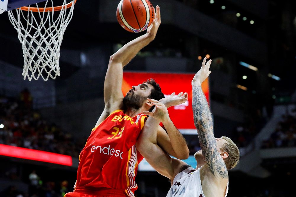 El alero de la selección de baloncesto de España, Javier Beirán (i) lanza a canasta ante la defensa del escolta de Letonia, Janis Timma (d).