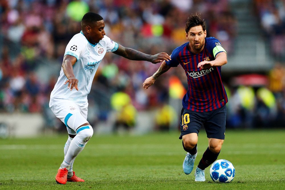 Messi (d), lucha por el balón frente al centrocampista holandés del PSV Eindhoven Pablo Rosario.