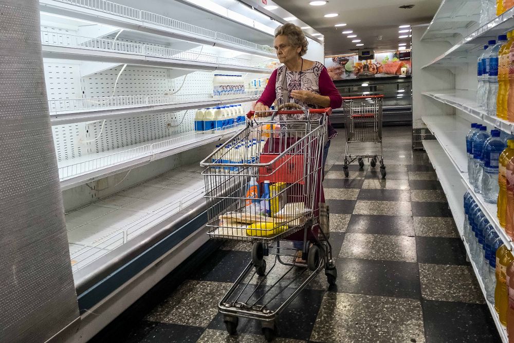 Una mujer busca productos en un supermercado de Caracas.