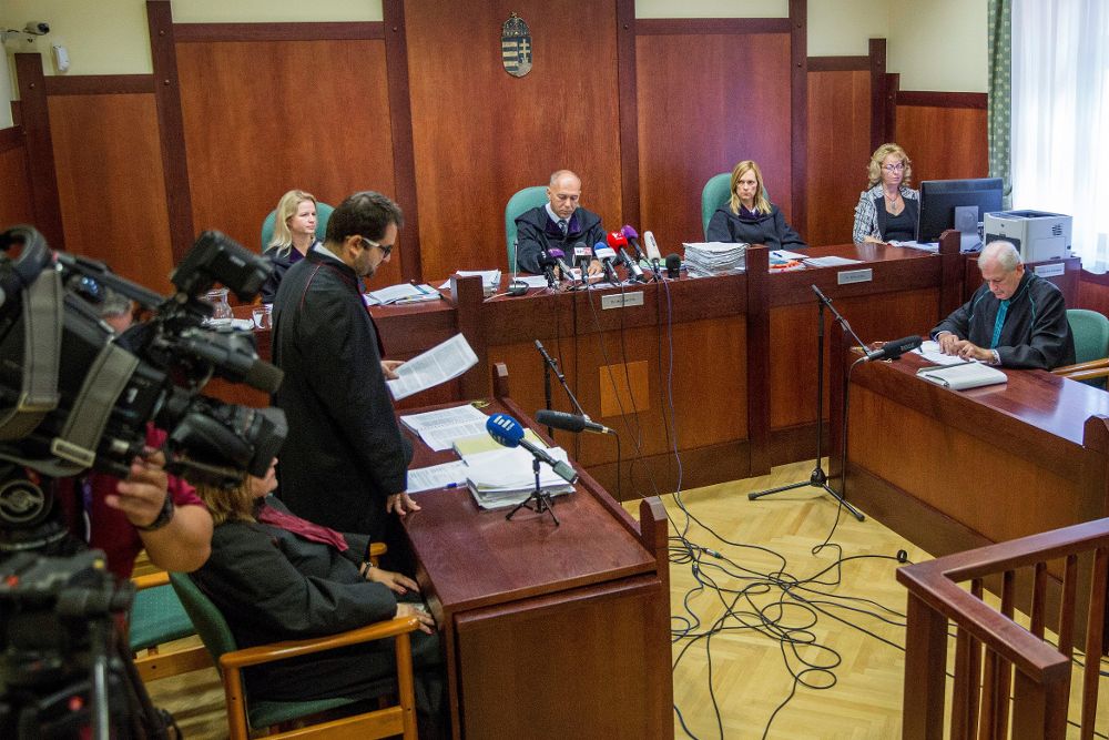 El juez Erik Mezolaki (c) y el abogado de la defensa Peter Barandy (d) escuchan al fiscal Istvan Voros (i) durante el juicio de apelación del refugiado sirio Ahmed H. en Szeged (Hungría).