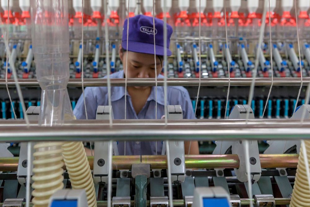 Una mujer trabaja en una fábrica textil de Talak, en Wuxi, en la provincia de Jiangsu (China).