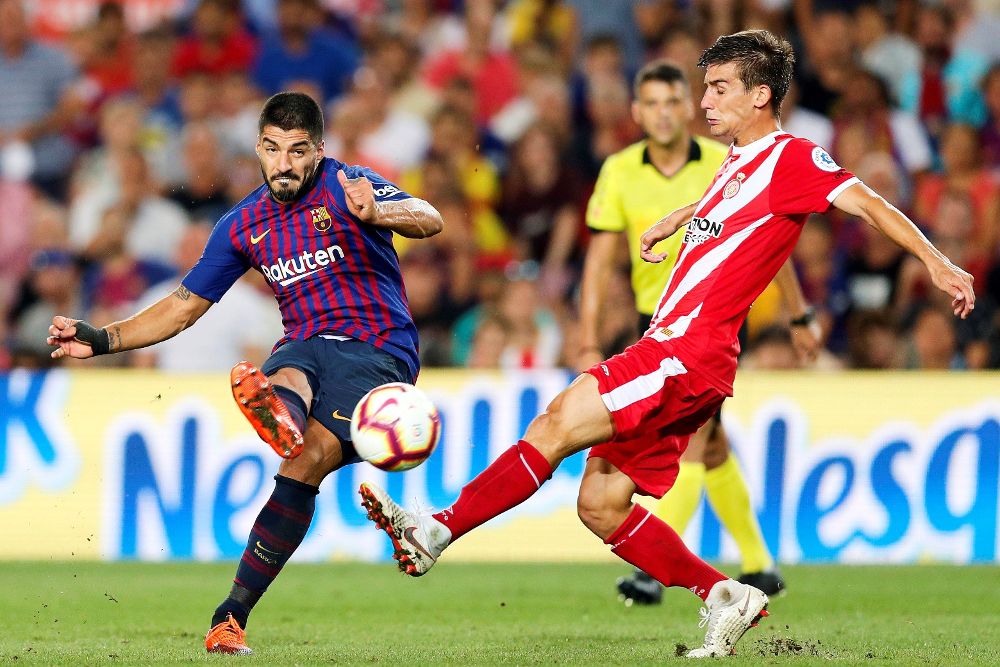 El delantero del FC Barcelona Luis Suárez (i) chuta ante Pere Pons, del Girona.