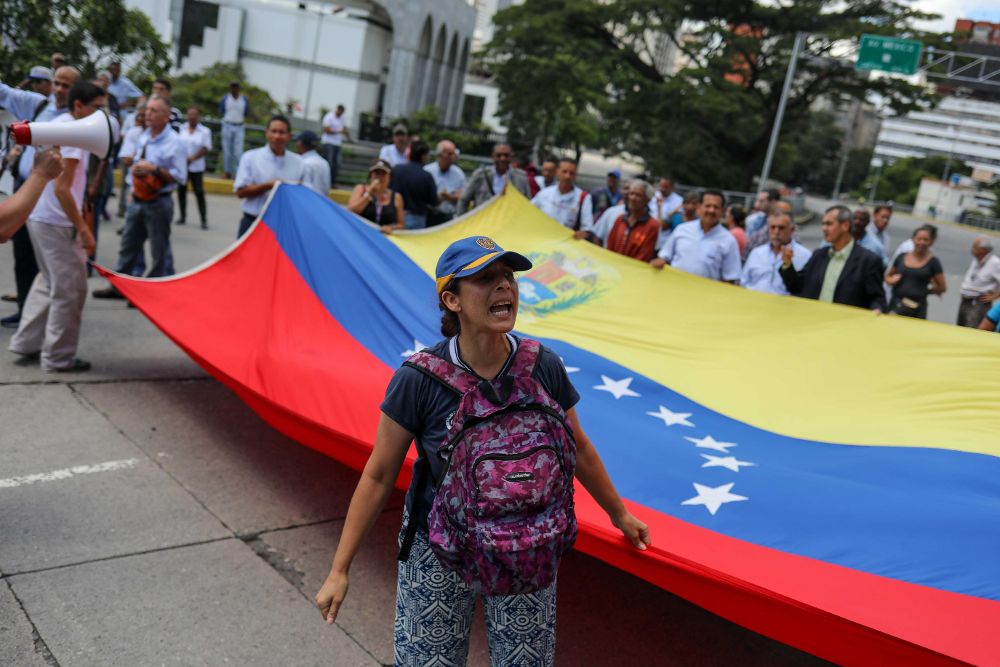 Trabajadores de diferentes sectores participan en una protesta en Caracas contra las medidas económicas aplicadas por Nicolás Maduro.