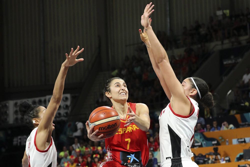 La jugadora de la selección española de baloncesto Alba Torrens (c) lucha con las canadienses Miranda Ayin (i) y Natalie Achonwa (d).