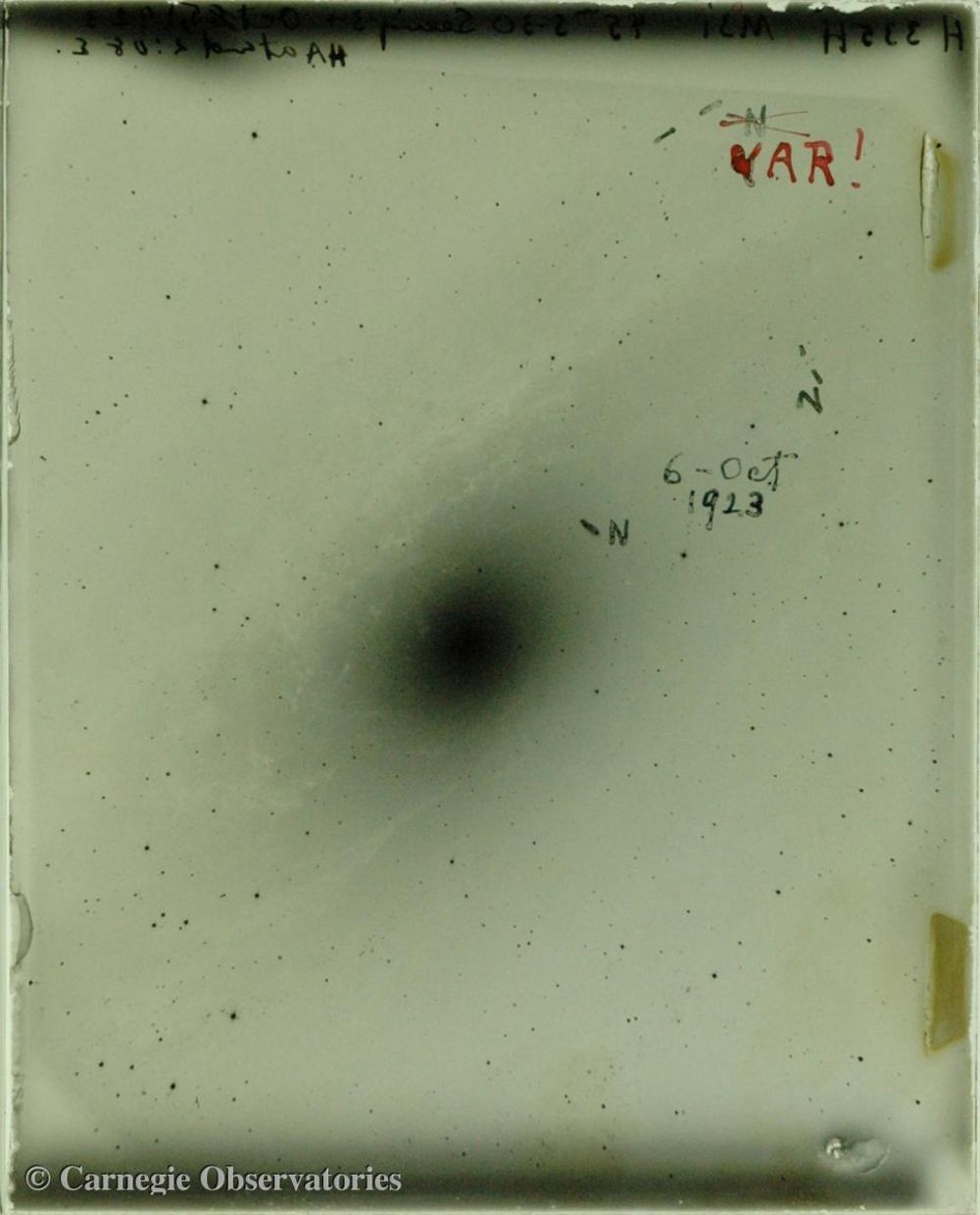 Detalle de la placa fotográfica obtenida por Edwin Hubble en 1924 de la "nebulosa" de Andrómeda. En ella, el astrónomo anotó la posición de algunas novas y de la estrella Cefeida variable con la que determinó la distancia hasta esa galaxia. Cortesía de los Observatorios Carnegie. 