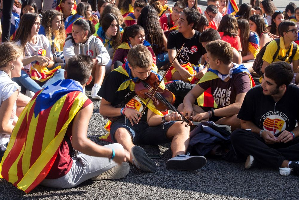 Varios jovenes cortan la Gran Vía de Barcelona antes de iniciarse la manifestación.