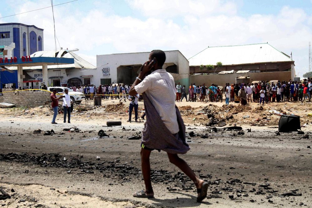 Un hombre camina cerca del escenario de una explosión, en Mogadishu (Somalia).
