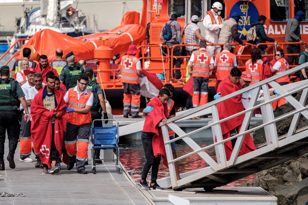 Efectivos de la Cruz Roja atienden a los 21 inmigrantes magrebíes rescatados por Salvamento Marítimo de una patera avistada a 50 millas náuticas (92 kilómetros) al norte de Gran Canaria, esta tarde a su llegada al Muelle Deportivo de Las Palmas de Gran Canaria.