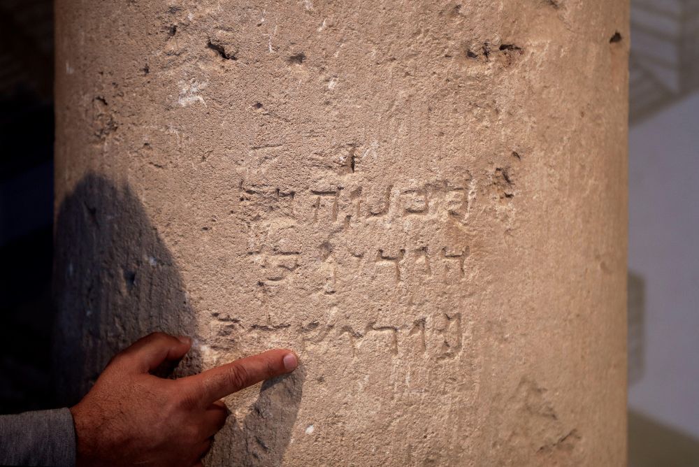 Un arqueólogo de la Autoridad de Arqueología de Israel muestra la piedra que lleva una inscripción de 2.000 años de antigüedad en la que se lee en hebreo "Jerusalén".
