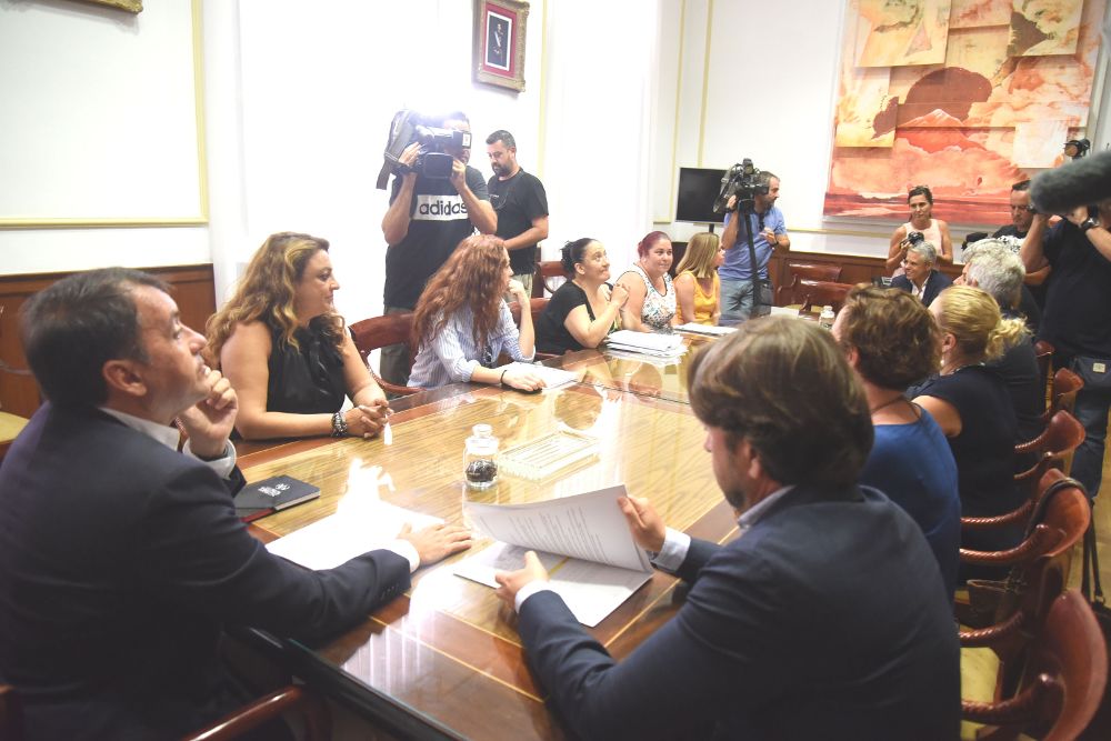 Una reunión del alcalde de Santa Cruz (i), el presidente del Cabildo tinerfeño (a su derecha) y la consejera de Empleo, Vivienda y Políticas Sociales del Gobierno canario (2ª i) con los afectados.
