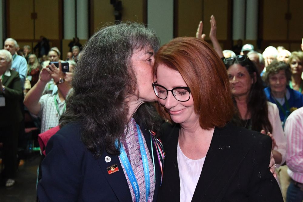 La ex primera ministra de Australia Julia Gillard (d) recibe un beso de Chrissie Foster durante el homenaje nacional a las víctimas infantiles de abusos sexuales, en el Parlamento.