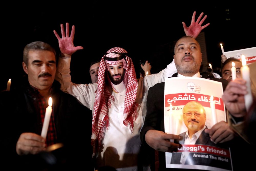 Un hombre muestra una careta del príncipe heredero saudí, Mohamed bin Salman, y las manos pintadas de color rojo, simulando sangre, durante una manifestación frente al consulado de Arabia Saudí en Estambul, por la muerte del periodista Jamal Khashoggi.