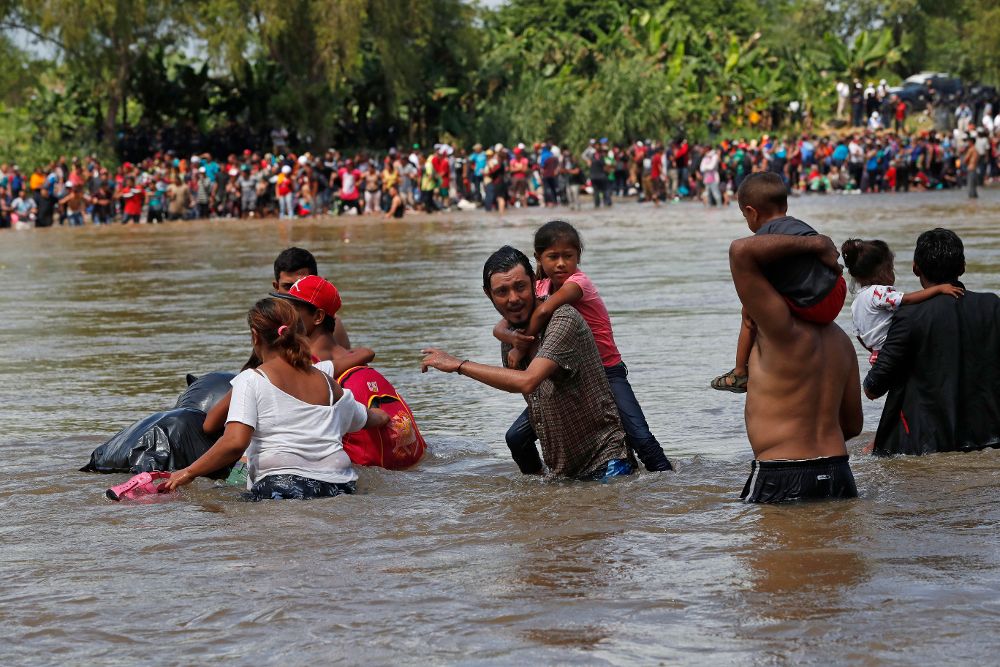 Migrantes hondureños cruzan a pie el río Suchíate desde Guatemala hoy, lunes, en Ciudad Hidalgo (México). 
