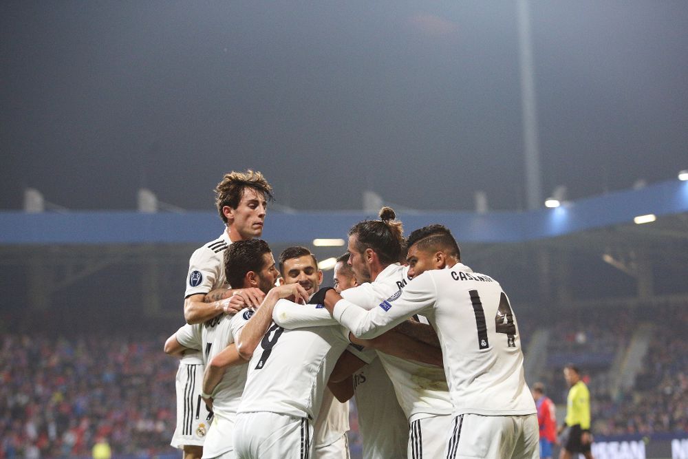 Karim Benzema (C) es abrazao por sus compañeros tras marcar un gol.