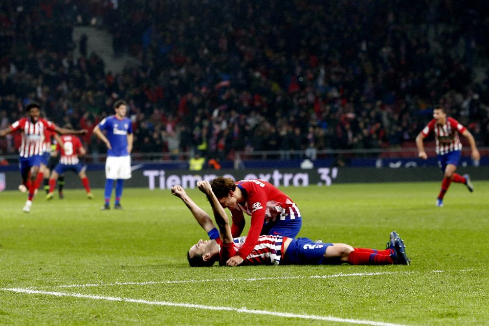 Los jugadores del Atlético de Madrid, el uruguayo Diego Godín (suelo) y el francés Antoine Griezmann celebran el tercer gol del equipo rojiblanco.