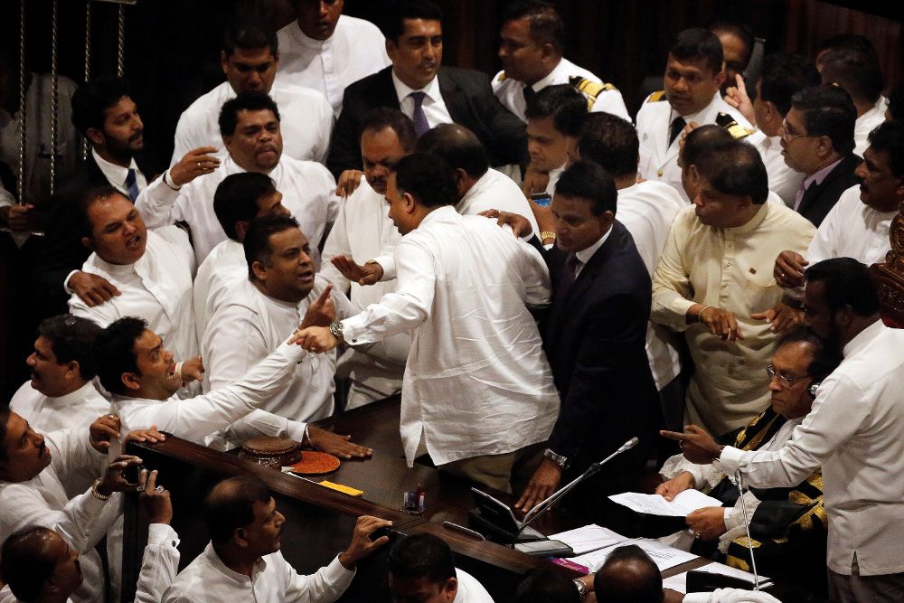 Miembros del gobierno y de la oposición rodean al presidente de la Cámara, Karu Jayasuriya (c).