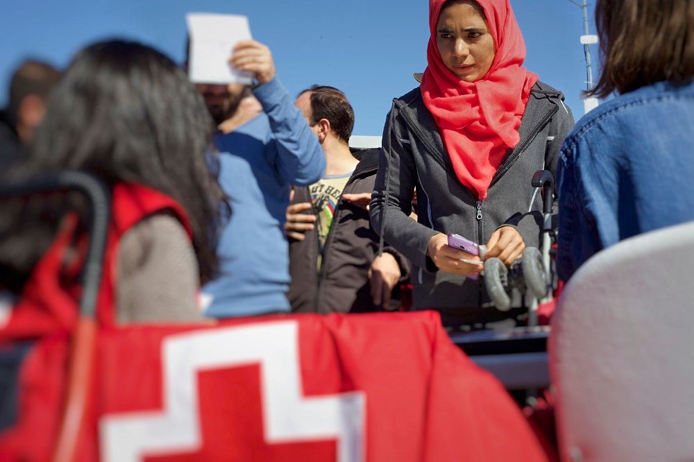 Voluntarios de Cruz Roja con refugiados.