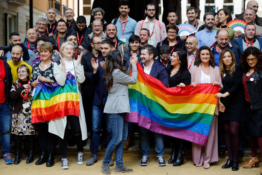 Diputados y miembros de grupos y de colectivos LGTBI durante la foto de familia tras el pleno de Les Corts Valencianes.