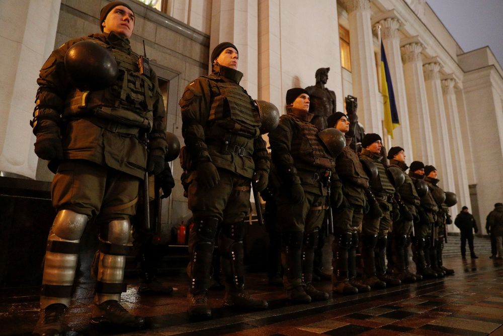 Varios policías antidisturbios montan guardia frente al Parlamento durante una manifestación en Kiev (Ucrania), hoy, tras declararse el estado de excepción en todo el país.