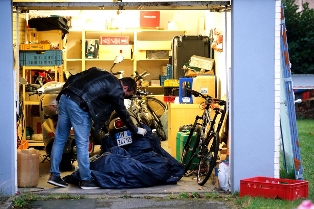 Un agente de policía registra el garaje de una vivienda bajo sospecha, en Pulheim, Alemania.