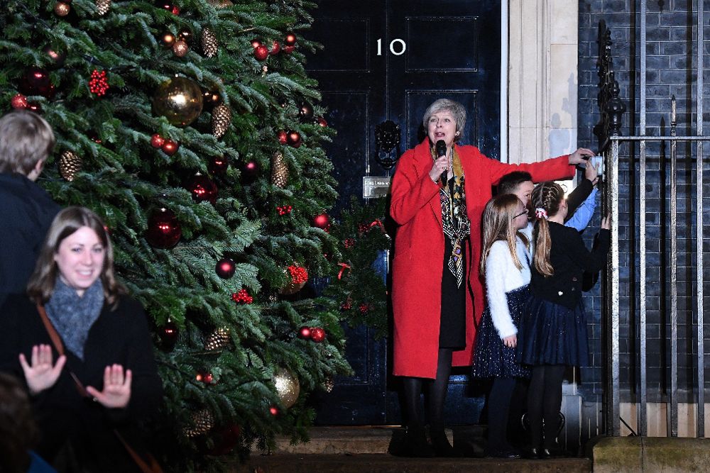 Theresa May (i), y un grupo de niños se preparan para encender el alumbrado navideño del número 10 de Downing Street en Londres (Reino Unido) el 6 de diciembre de 2018. 