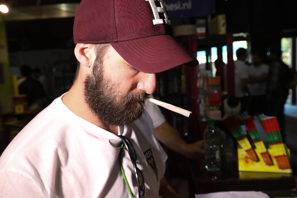 Un hombre se dispone a encender un cigarrillo de cannabis.