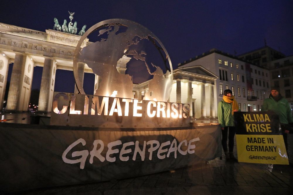 Activistas de Greenpeace protestan contra el cambio climático ante la Puerta de Brandemburgo en Berlín (Alemania) hoy, 11 de diciembre.