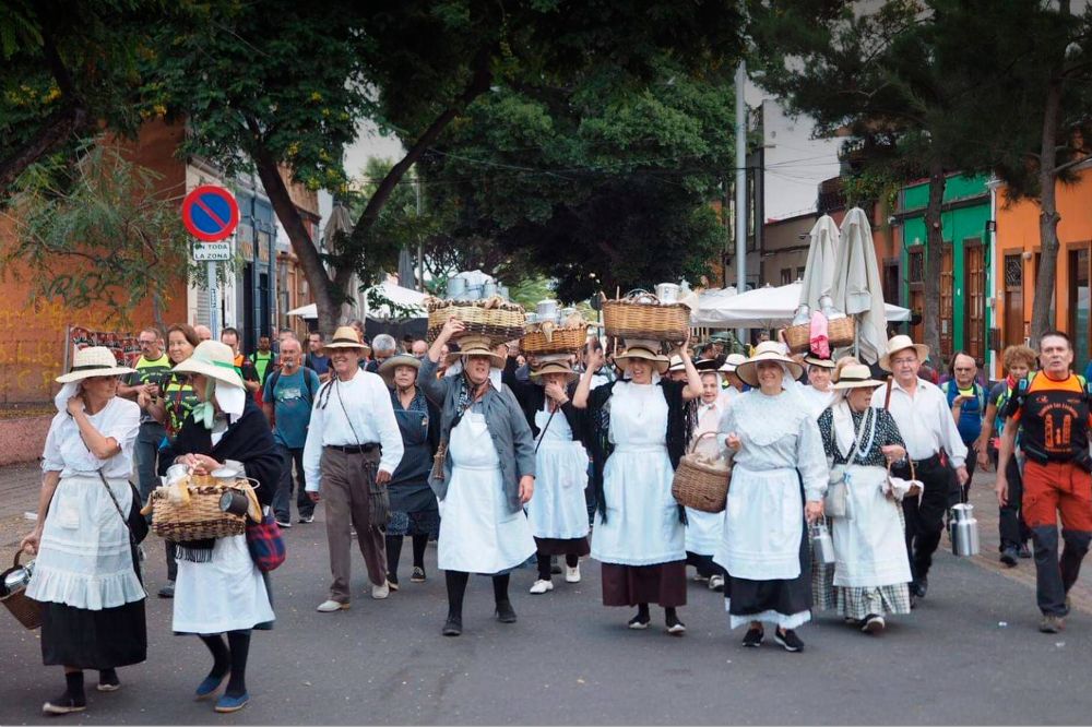 Un grupo de mujeres ataviadas como las tradicionales lecheras recorre la calle de La Noria, en Santa Cruz, en el inicio del camino a La Laguna.