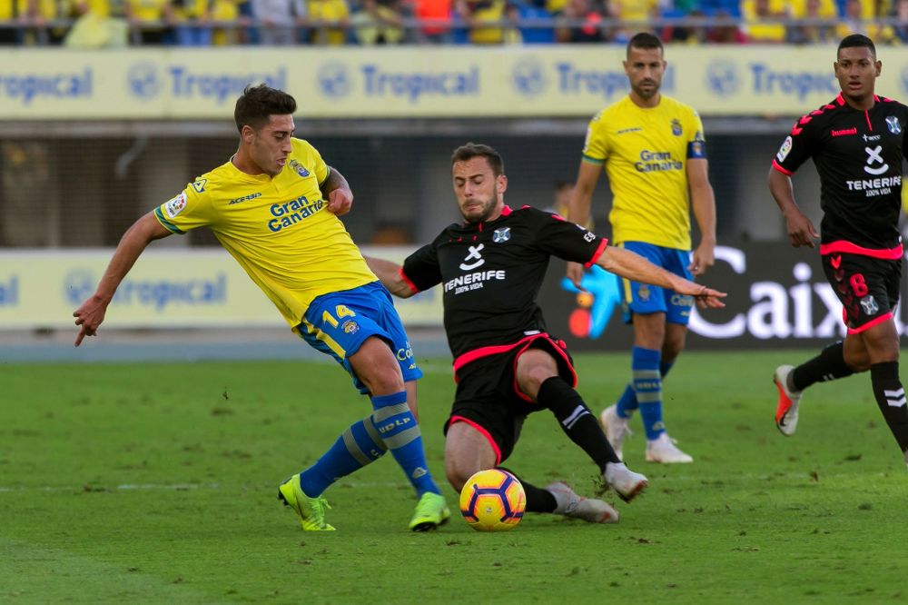 El defensa de la UD Las Palmas Álvaro Lemos (i) intenta un pase ante dos jugadores del CD Tenerife.