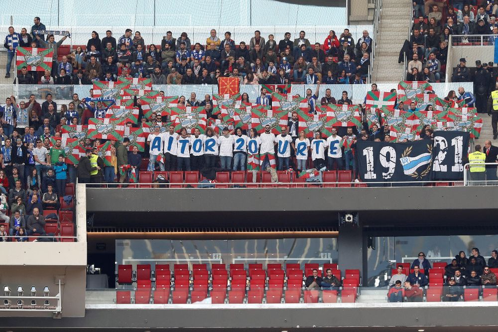 Aficionados que asistían al partido entre el Atlético de Madrid y el Alavés, en el Wanda Metropolitano, rinden homenaje al aficionado de la Real Sociedad Aitor Zabaleta, al cumplirse veinte años de su muerte.