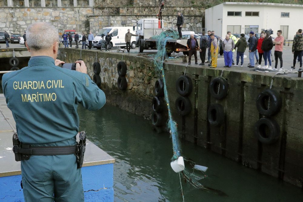 Trabajadores del puerto de Malpica (A Courña) recogen la red del pesquero "O Silvosa".