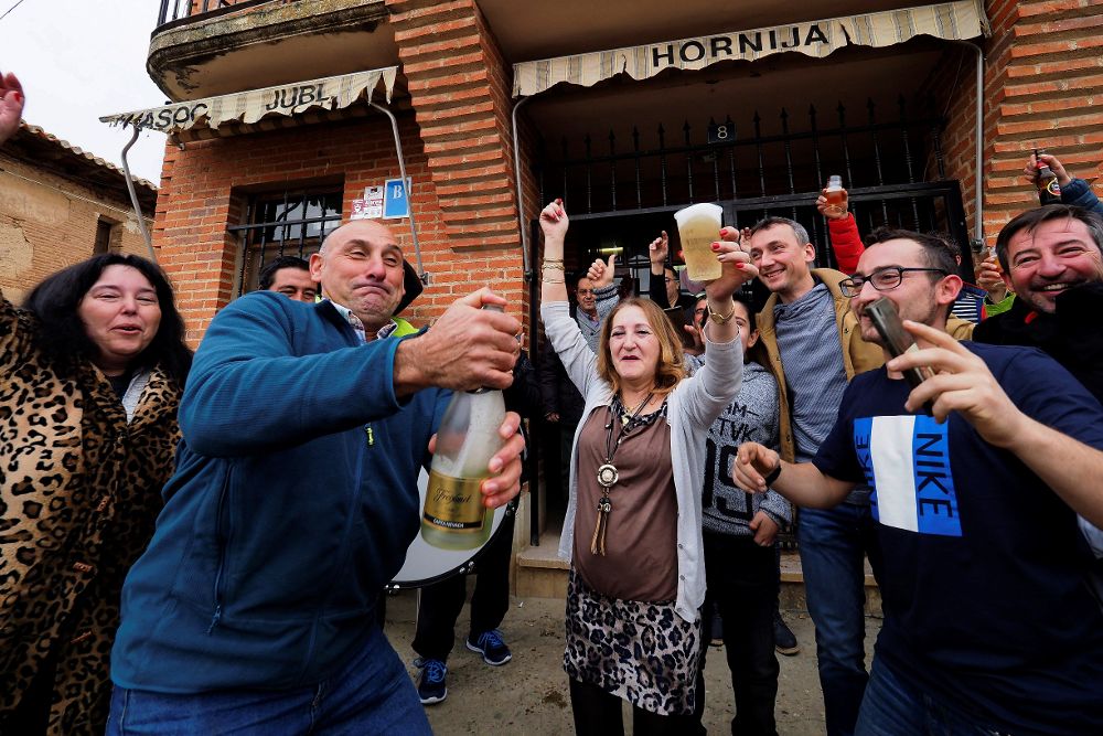Vecinos de San Román de la Hornija (Valladolid) celebran los 2,4 millones de euros en premios del número 7.568, agraciado hoy con uno de los quintos del sorteo de Navidad de la Lotería Nacional que ha llevado el bar de la localidad desde la administración de lotería de Toro (Zamora).