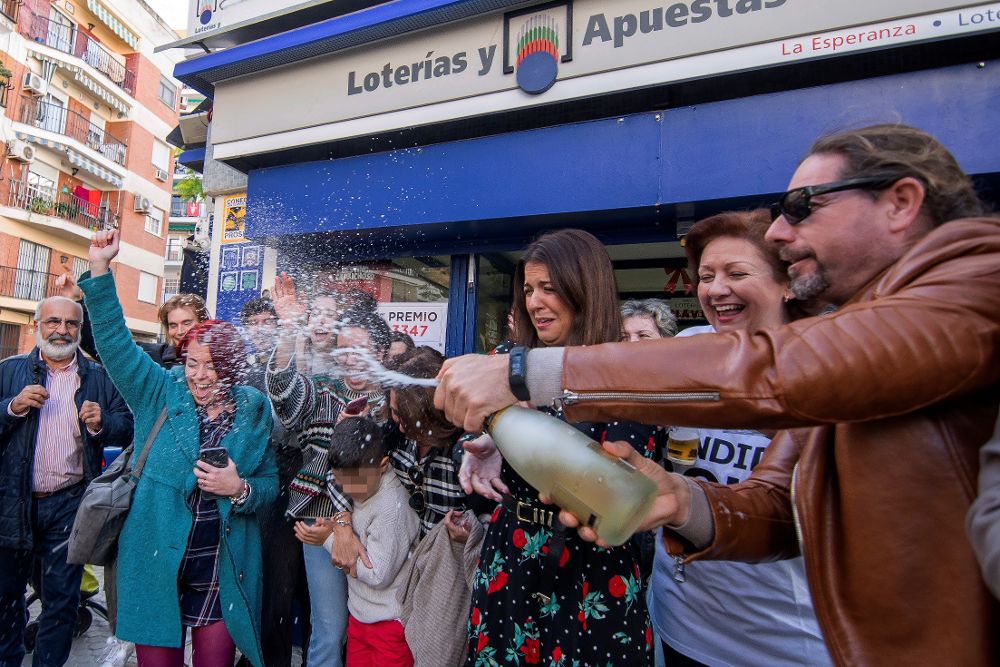 Celebración en la administración de loterías número 93, establecida en el barrio de Triana, en la calle Numancia, de Sevilla, que ha vendido cinco décimos del Gordo, el número 03.347 todos ellos expedidos por máquina. 