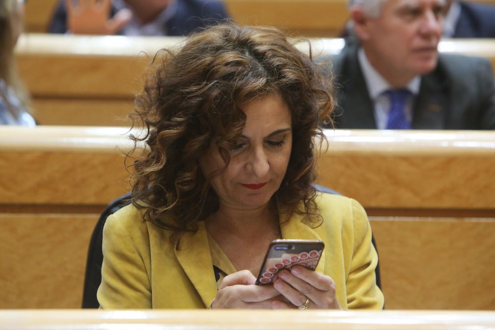 La ministra de Hacienda, María Jesús Montero, consulta su móvil.