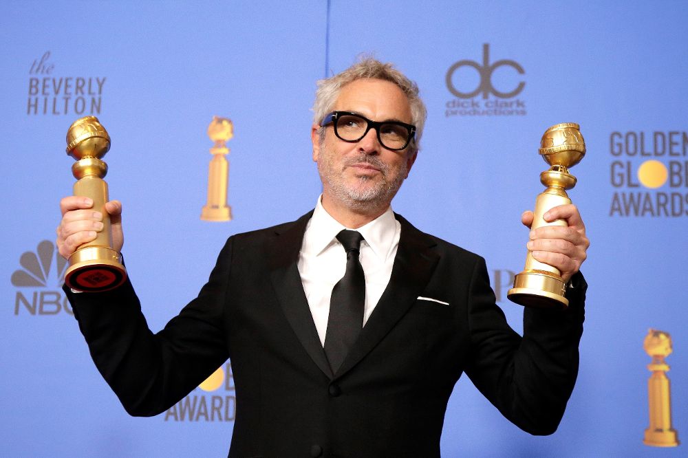 El cineasta mexicano posa con sus galardones a mejor director y mejor película en lengua extranjera por su largometraje "Roma", durante la 76 edición de los Globos de Oro.