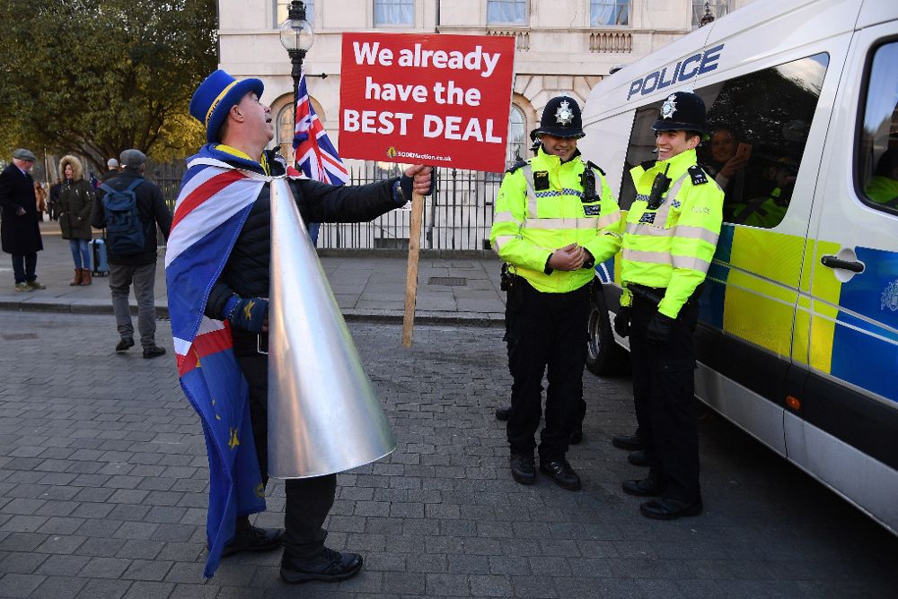 Un activista en contra del "brexit" se dirige a dos policías ante el Parlamento en Londres.