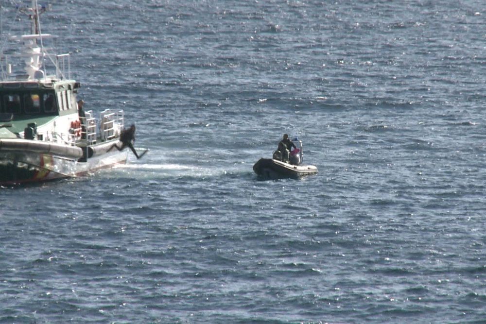Una patrullera con buzos de la Guardia Civil rastrea la costa de Los Ancones.