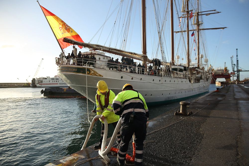 Dos amarradores ayudan al atraque del buque escuela de la Armada en el puerto de la capital tinerfeña.