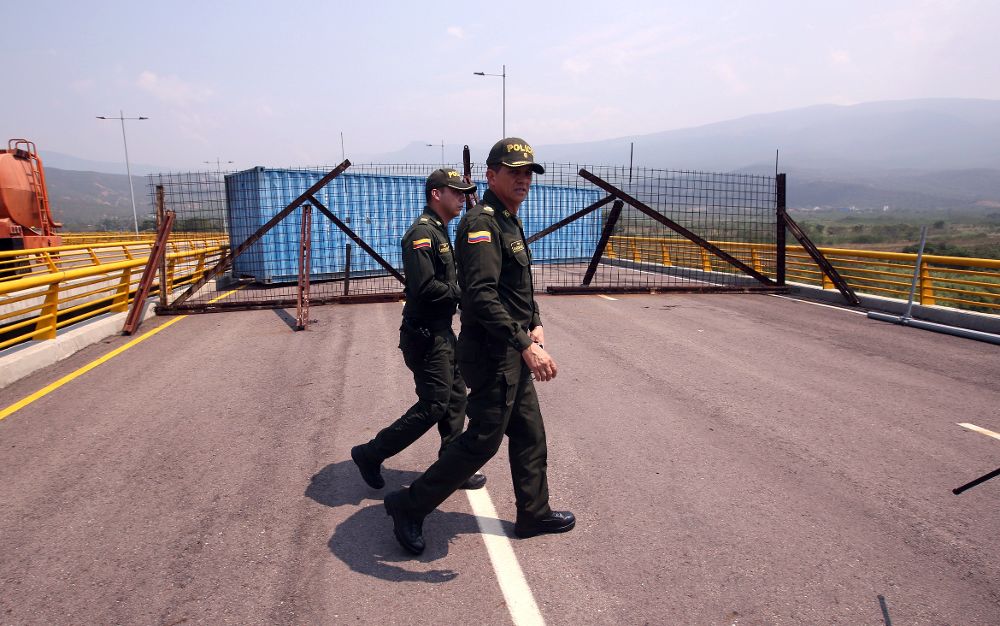 Policías colombianos prestan guardia en el puente Tienditas este miércoles, sector Boconó, en Cúcuta (Colombia). La Guardia venezolana bloquea este puente en desuso para evitar el ingreso de la ayuda humanitaria anunciada por el presidente de la Asamblea Nacional, Juan Guaidó.