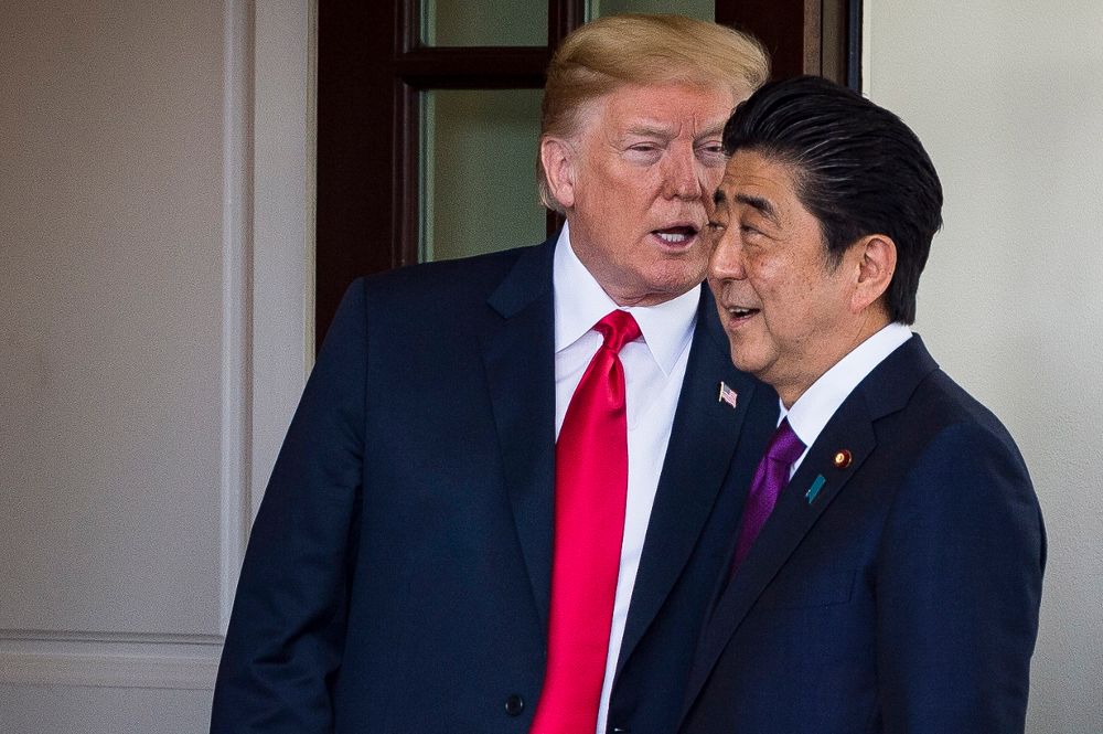 Donald Trump (i) le susurra algo al oído al primer ministro japonés, Shinzo Abe, a la entrada del Al Oeste de la Casa Blanca.