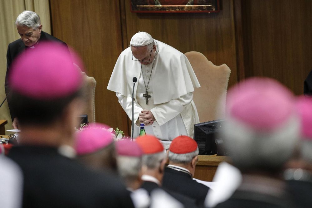 El papa Francisco (c) reza al inicio de la segunda jornada de la reunión que se celebra en el Vaticano sobre los abusos a menores por parte del clero. 