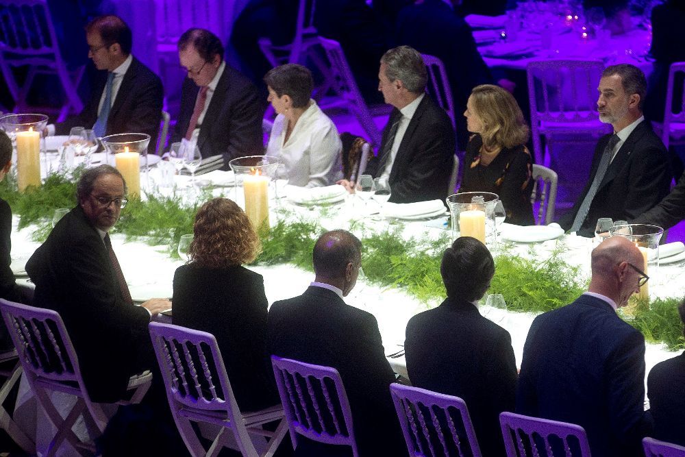 El rey Felipe VI (d) y el presidente de la Generalitat, Quim Torra (i-primer término), entre otros, durante la cena de inauguración del Mobile World Congress.