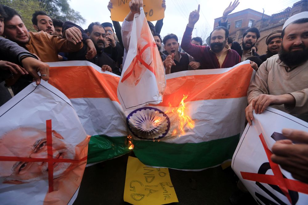 Manifestantes paquistaníes queman una bandera india y una imagen del primer ministro indio, Narendra Modi, durante una protesta tras el bombardeo indio.