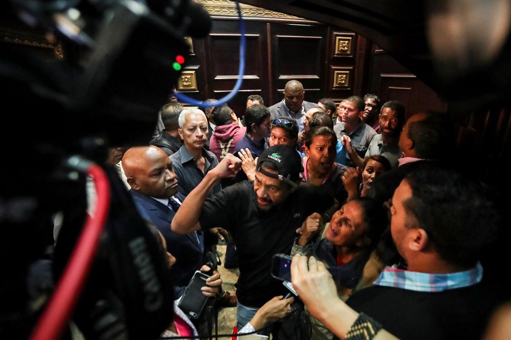 Un grupo de personas adeptas al oficialismo intenta ingresar a la fuerza a la Asamblea Nacional (AN, Parlamento) de Venezuela, ayer, miércoles.
