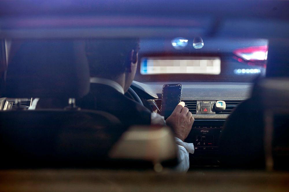 Un conductor revisa la aplicación de Cabify en su vehículo este jueves en Barcelona.