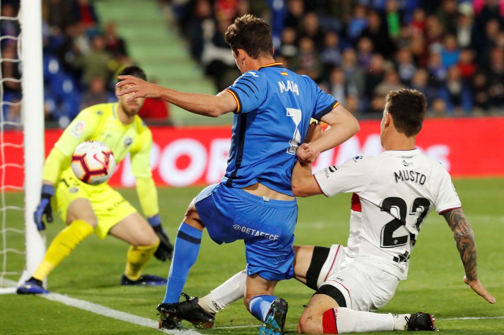 El delantero del Getafe, Jaime Mata (i), pelea un balón ante el centrocampista argentino del Huesca, Damián Musto (d).
