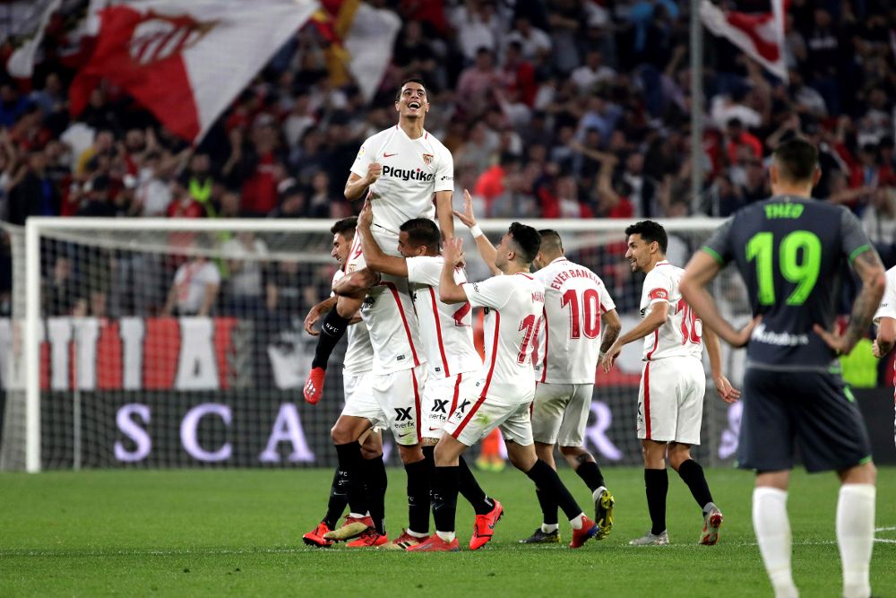 El delantero francés del Sevilla Wissam Ben Yedder (arriba) es felicitado por sus compañeros tras marcar su tercer gol ante la Real Sociedad.