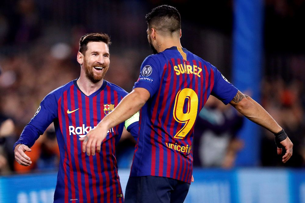 Lionel Messi (i) celebra con su compañero Luis Suárez su primer gol ante el Olympique.