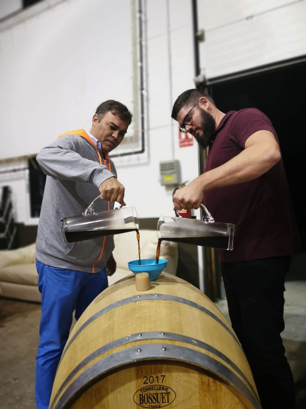 Dos operarios llenan un barril con la cerveza de Agaete.