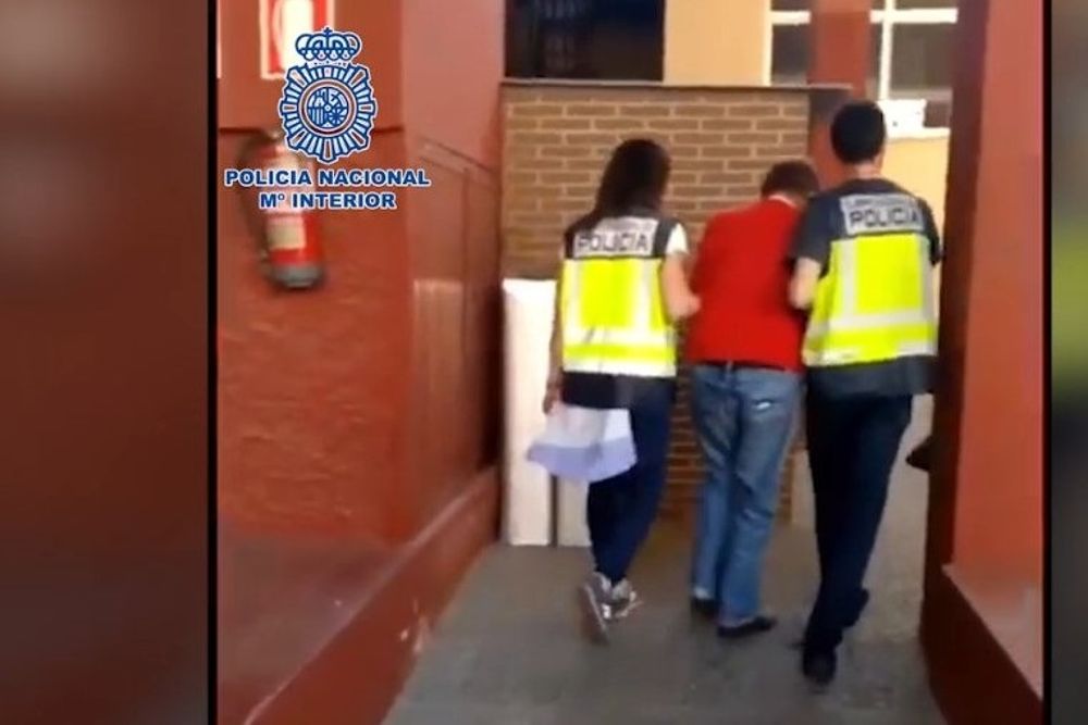 El fugitivo británico detenido en Almería es conducido por dos policías.